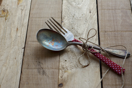Vintage silverware on rustic wooden plateの写真素材