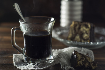 Hot coffee in transparent cup on dark brown backgroundの写真素材