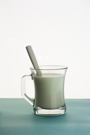 transparent mug of milk on blue backgroundの写真素材