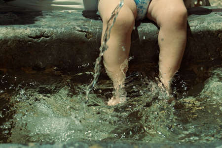 baby with feet in the cool waterの写真素材