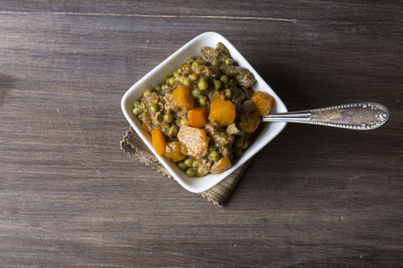 hot beef stew with carrots and tomato sauce, on wooden backgroundの写真素材