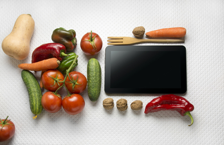 Digital tablet with fresh vegetables on white backgroundの写真素材