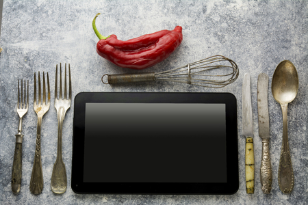 Digital tablet, with whisk and antique silverware, on grunge backgroundの写真素材