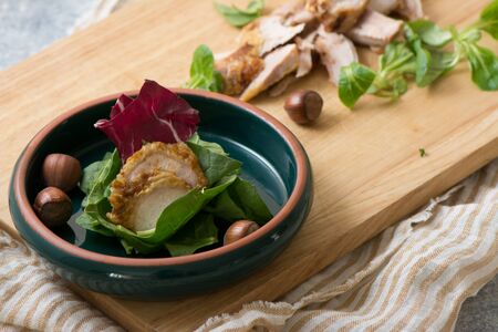 Slices of chicken fillet on spinach and lettuce on bowlの写真素材