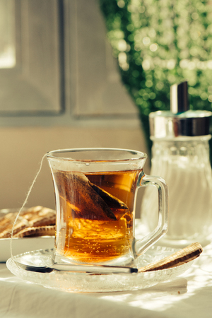 healthy cup of hot tea on breakfast table, with morning lightの写真素材