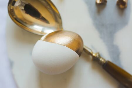 Easter: place setting, elegant gold and white egg, on marble plate. Close upの写真素材