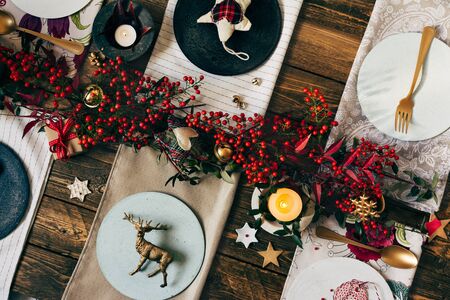 Holiday Gold place setting, funny Christmas table with ornaments and natural berries, on wooden table, overhead shootの写真素材