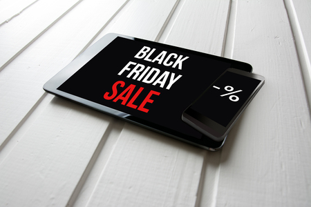 Black friday sale promotion on computer tablet screen, on white wood, online shopping concept.の写真素材