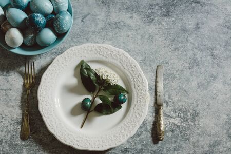 view of naturally colored Easter eggs and table setting for lunch, on dark grunge background. Above viewの写真素材