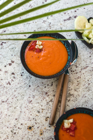Spanish Gazpacho cold vegetable soup made of tomato, cucumber, bell pepper, onion, garlic and olive oil served in ceramic bowl . Top viewの写真素材