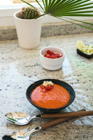 Spanish Gazpacho cold vegetable soup made of tomato, cucumber, bell pepper, onion, garlic and olive oil served in ceramic bowl .の写真素材