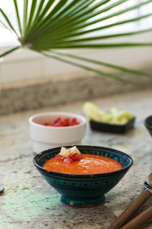 Spanish Gazpacho cold vegetable soup made of tomato, cucumber, bell pepper, onion, garlic and olive oil served in ceramic bowl .の写真素材
