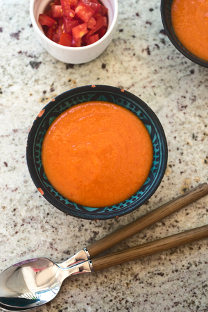 Spanish Gazpacho cold vegetable soup made of tomato, cucumber, bell pepper, onion, garlic and olive oil served in ceramic bowl . top viewの写真素材