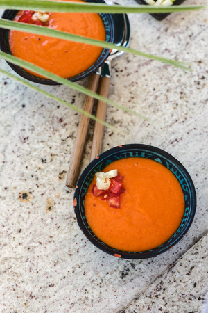 Spanish Gazpacho cold vegetable soup made of tomato, cucumber, bell pepper, onion, garlic and olive oil served in ceramic bowl . Top viewの写真素材