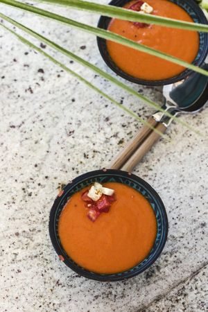Spanish Gazpacho cold vegetable soup made of tomato, cucumber, bell pepper, onion, garlic and olive oil served in ceramic bowl . From top viewの写真素材
