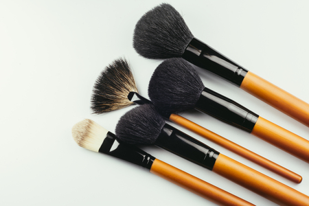 Various wooden makeup brushes isolated over whiteの写真素材