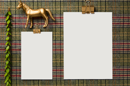 Empty holiday menu, decorated with golden ornaments, on the table with checkered tablecloth, From above. Christmas background or thanksgivingの写真素材