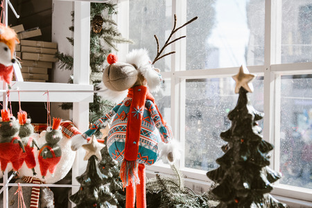 Christmas decorations, reindeer doll with bright colors next to the window in winter. Indoorの写真素材