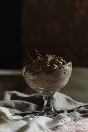 Chocolate mousse in glass cup, rustic tablecloth, mystic light foodの写真素材