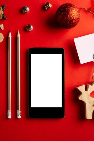 Christmas empty mobile phone on red background, Holiday planning and xmas ornamentの写真素材