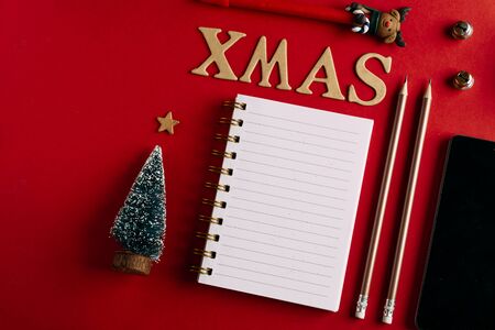 Christmas shopping list and mobile phone, Holiday planning red background, notebook and christmas decorationの写真素材