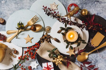 Holiday table setting, funny Christmas table with ornaments and natural berries, on blue tableの写真素材