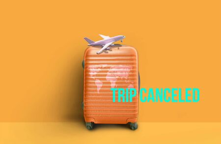 COVID-19.Orange World Map Travel Luggage and plane "Trip cancellation". Stop travel to risk places COVID-19. prevention of contagion. Coronavirus crisis in travel and tourism industry conceptの写真素材