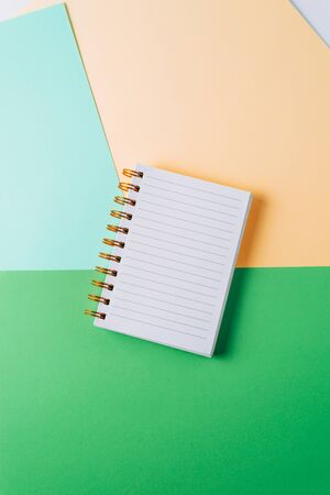 notebook with blank sheet and golden spiral on a colorful pastel background.の写真素材