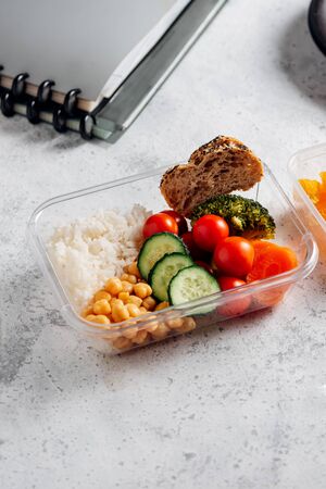 Healthy food in lunch box, on working table with working elementsの写真素材