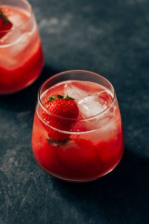 two strawberry cocktail with ice on dark backgroundの写真素材