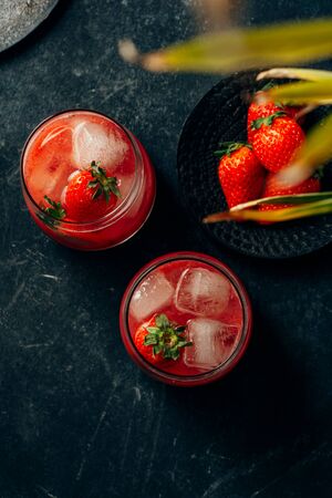two strawberry cocktail with ice on dark backgroundの写真素材