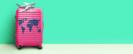 Lime green suitcase standing next to the color wall. Concept travelの写真素材