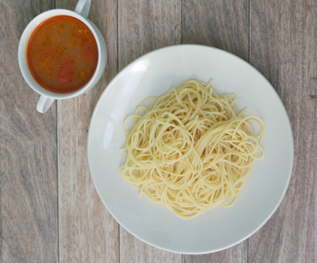 spaghetti with tomyum soup on wood backgroundの写真素材