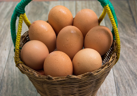 eggs in the basket on wood backgroundの写真素材
