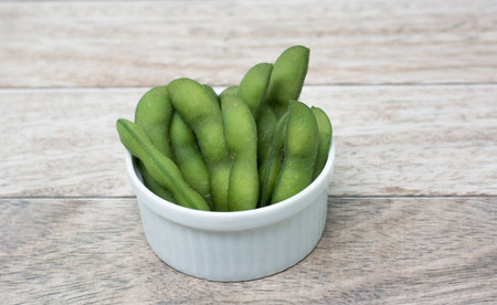 soybean in white bowl on wood backgroundの写真素材