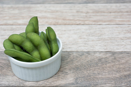 soybean in white bowl on wood backgroundの写真素材