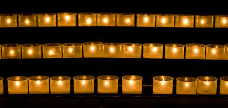 a line of burning candles in a churchの写真素材
