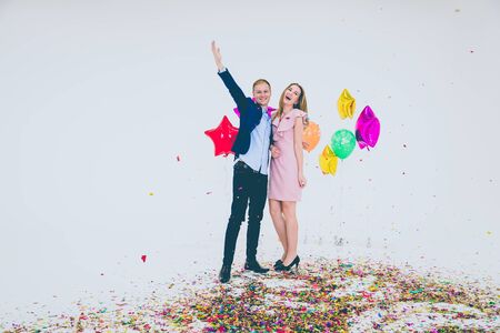A young woman in the pink dress and a young man in the suit and jeans with merry Christmas, Happy New Year.の写真素材