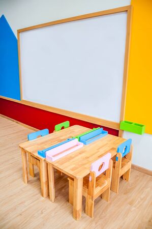 Desks, chairs and white board in the kindergarten classroom.の写真素材