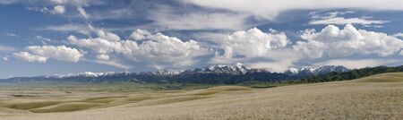 Beautiful waves of hills in the background of cloudの写真素材