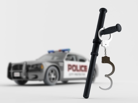 Baton and handcuffs on the background of a police carの写真素材