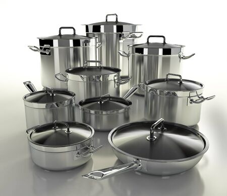 A set of stainless steel pans on a light backgrounの写真素材