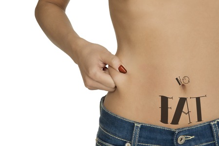 Young tattooed girl squeezing her body fat. Studio shot isolated on white.