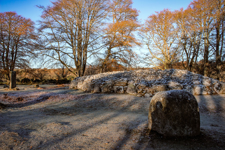 Close-up view of Clava Cairn near Inverness Scotland on a winter's morning with frost and sunlight beaming thrown the trees creating shadows.の写真素材