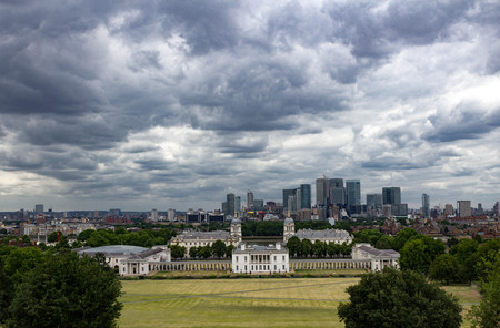Epic stormy view of Canary Warf, Maritime Museum, Old Royal Naval College and London Skyline from Greenwich Park, London England.のeditorial素材