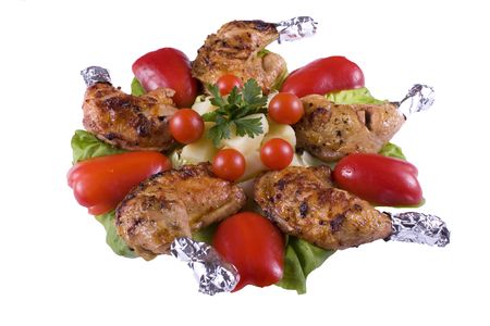 An isolated view of roasted chicken legs and a variety of delicious hot vegetables.  White backgroundの写真素材