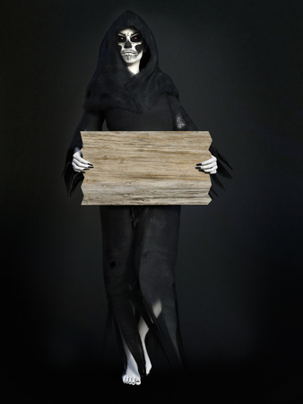 Female reaper or witch dressed in a black cloak holding a blank wooden sign, 3D rendering. Dark background.の写真素材