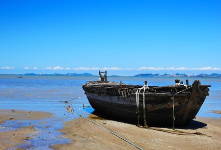 An old wooden boat at a sea shoreの写真素材