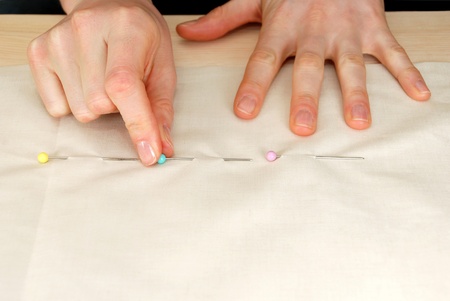 Closeup of a woman placing pins in fabric