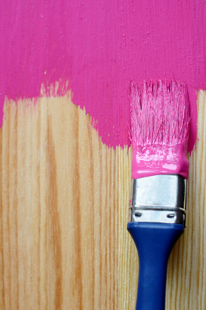 Closeup of pine plank being painted in a bright colour, with copy spaceの写真素材